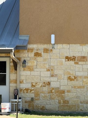 Outdoor Wi-Fi access point mounted on a stone exterior wall